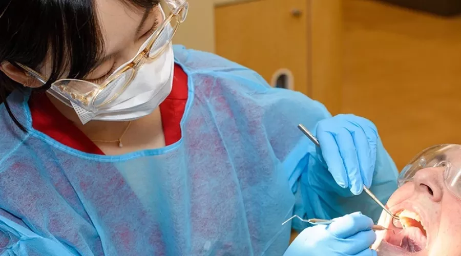 Dental student works in a patient's mouth